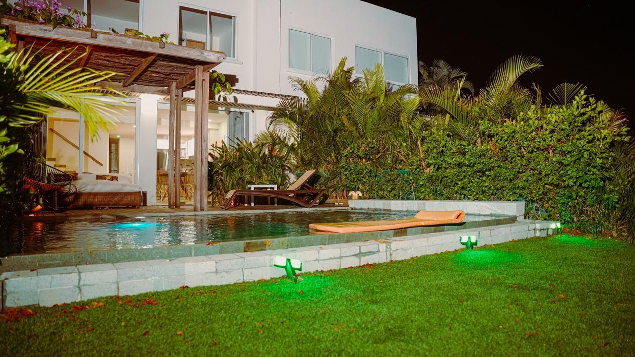 Piscina y casa iluminada de noche