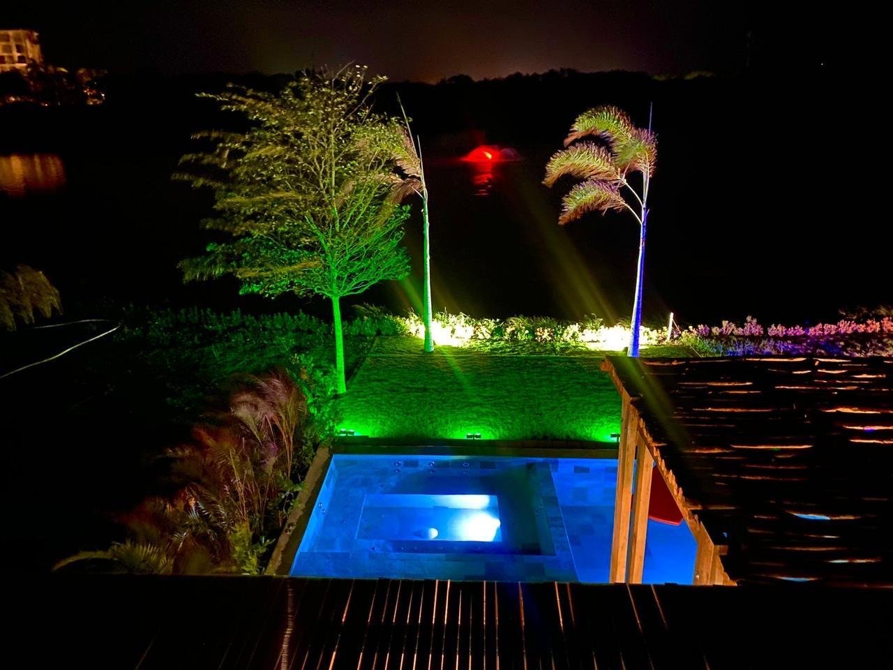 Jacuzzi y jardín iluminado de noche, con vista al lago
