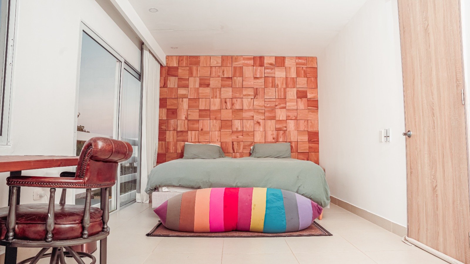 Cama king frente al muro de madera
